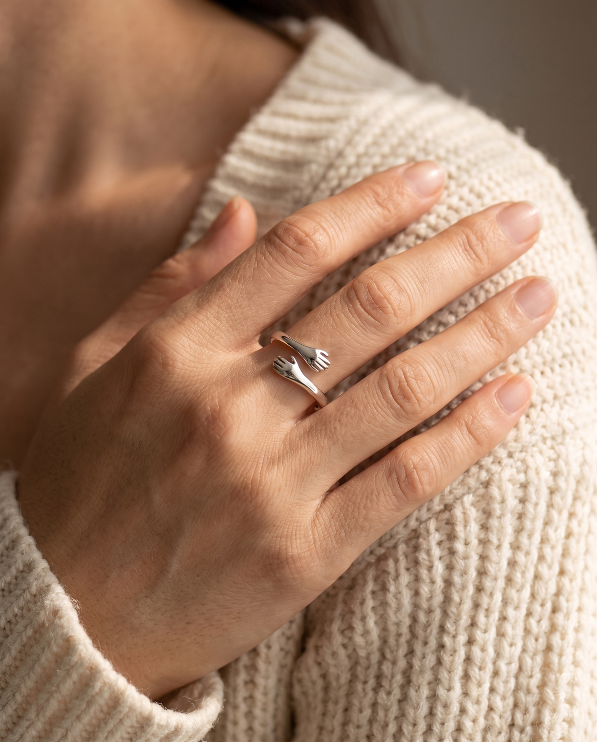 The Hug Ring worn on a woman's finger